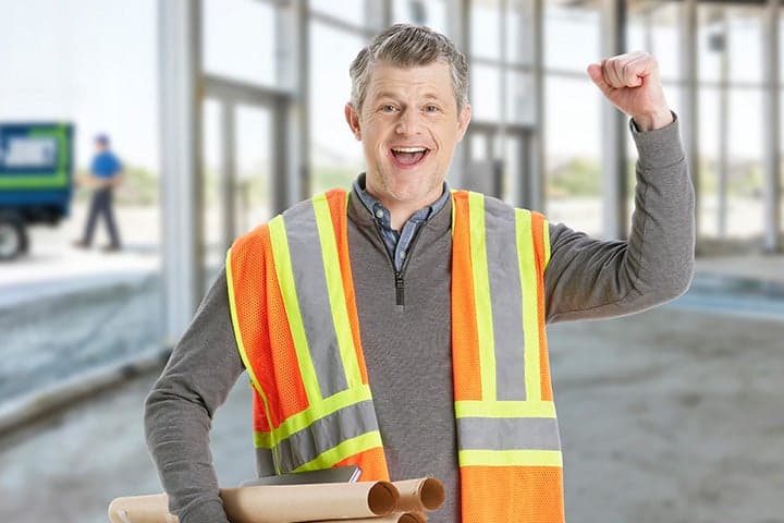 happy contractor at decluttered site with junk removal truck