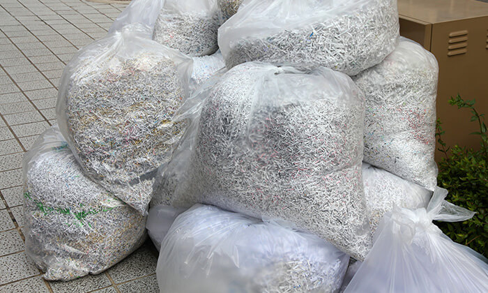 How to recycle shredded paper 1-800-GOT-JUNK? client dumping shredded paper waste into a large paper bag.