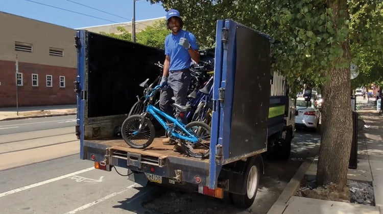 Truck team member in back of truck with bike