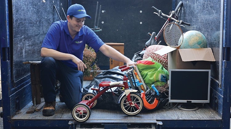 Truck team member in truck with red tricycle