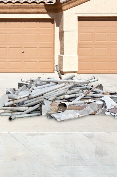 Driveway with a pile of scrap metal for pickup and disposal