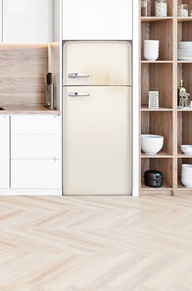 A kitchen with an old fridge and freezer ready for disposal and recycling