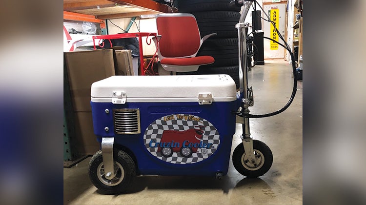 A cooler with wheels, handlebar and breaks