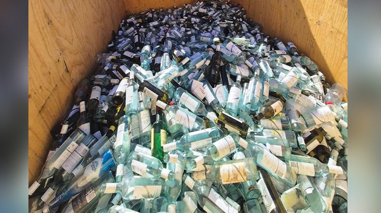 The back of a 1-800-GOT-JUNK? truck filled with hundreds of empty wine bottles