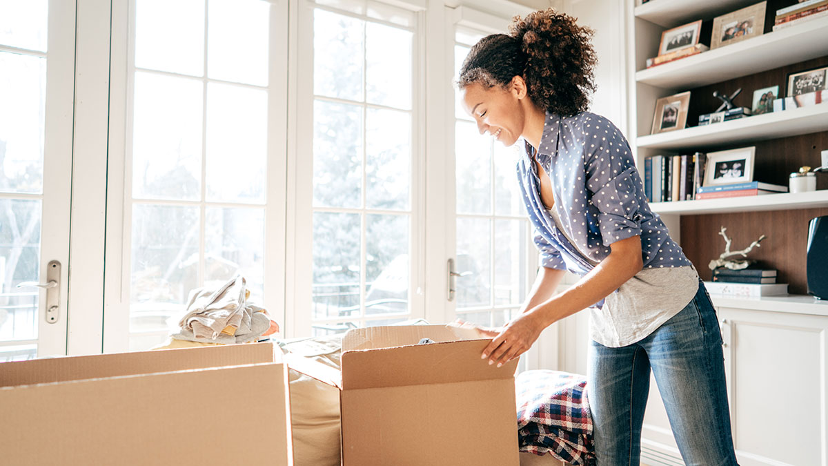 Femmes mettant ses objets dans des boîtes de carton.