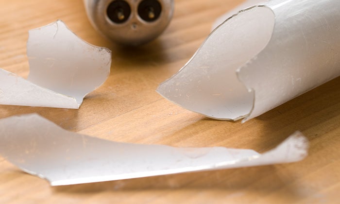 Broken fluorescent tube resting on a wooden surface