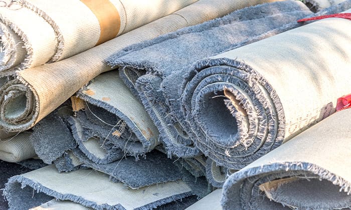 Stack of old rolls of carpet under natural lighting