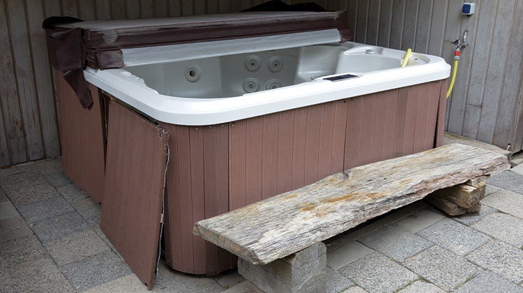 Old drained hot tub with top half off and side pannels removed