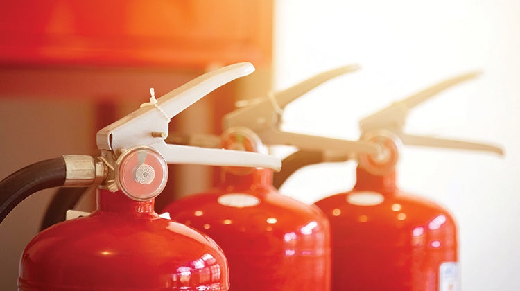 Top of three red fire extinguishers lined up