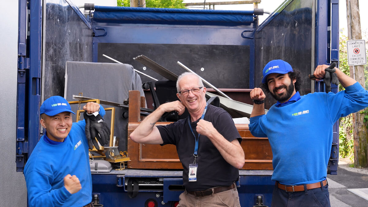 Russ Gray, Vancouver Japanese Learning School board member, smiling with two 1-800-GOT-JUNK? Truck Team Members as junk is removed.